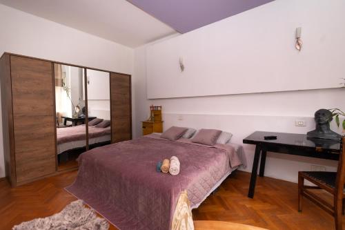 布加勒斯特sharing retro vintage luxury apartment的一间卧室配有一张床、一张桌子和一张桌子