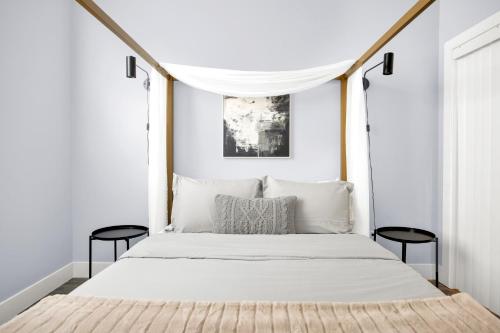 洛杉矶NoHo by AvantStay North Hollywood Townhome的一间卧室配有白色的床和两张黑色椅子