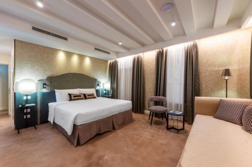 威尼斯阿卡酒店的酒店客房,配有床和沙发