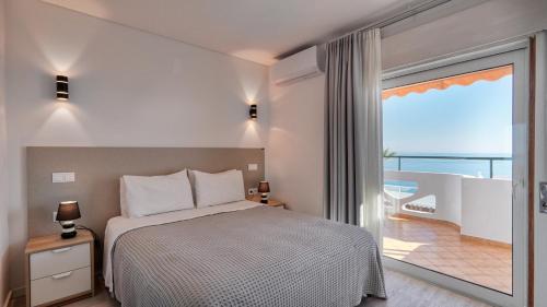 阿尔布费拉Guest House Dianamar的一间卧室设有一张床和一个大窗户