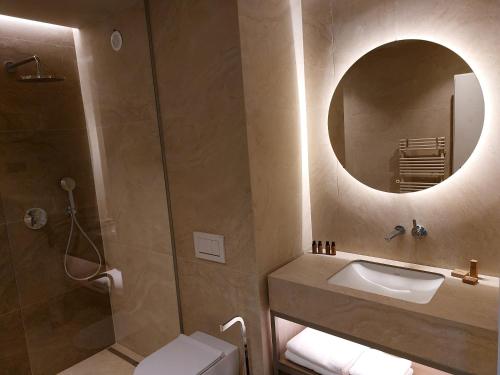 卢布尔雅那Tivoli Boutique Inn的一间带水槽和镜子的浴室