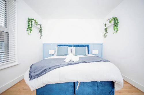 吉林汉姆3 bedroom-Contractors-Professionals的一间卧室配有一张大床和蓝色床头板