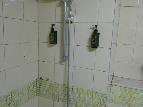 迪拜Ruby Star Hostel Loft Bed 21的墙上的淋浴和2瓶