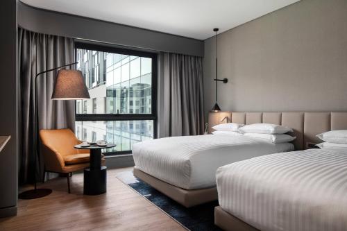 约翰内斯堡Marriott Executive Apartments Johannesburg, Melrose Arch的酒店客房设有两张床和窗户。