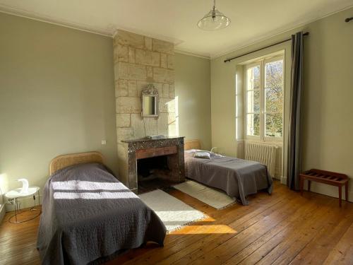 CadaujacChâteau Valoux的一间卧室配有一张床和一个壁炉