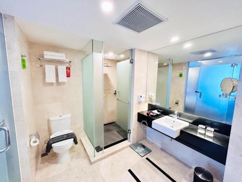 塞尔蓬大祖里BSD城市酒店的浴室配有卫生间、盥洗盆和淋浴。