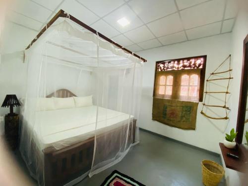 迪克韦勒Art house hiriketiya的一间卧室设有天蓬床和窗户。