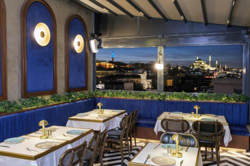 伊斯坦布尔Glamour Hotel Istanbul Sirkeci的一间带桌椅的市景餐厅