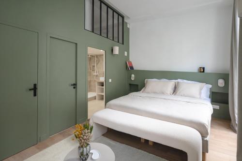 巴黎Noble Suites的卧室设有一张白色大床和绿色的墙壁