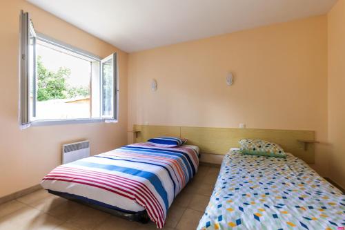 朗通Vacances apaisantes au coeur du Bassin d Arcachon的一间卧室设有两张床和窗户。