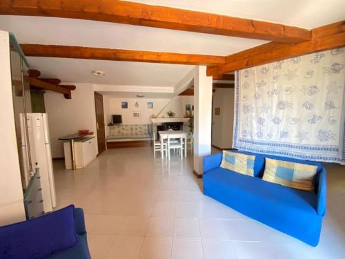 卡珀科达卡瓦洛Capo Coda Cavallo vista mare的一间带蓝色沙发的客厅和一间厨房