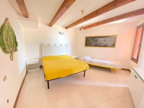 卡珀科达卡瓦洛Capo Coda Cavallo vista mare的一间卧室设有两张床和黄色毯子