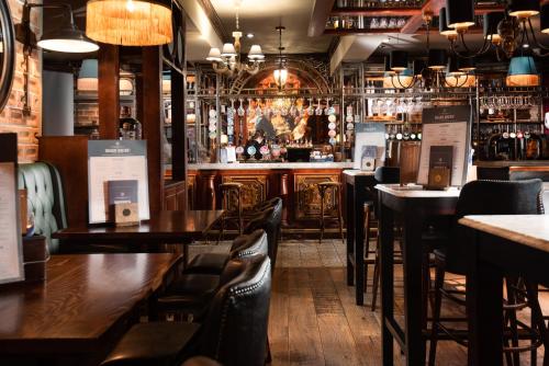 安布尔塞德The Temperance Inn, Ambleside - The Inn Collection Group的餐厅内带木桌椅的酒吧