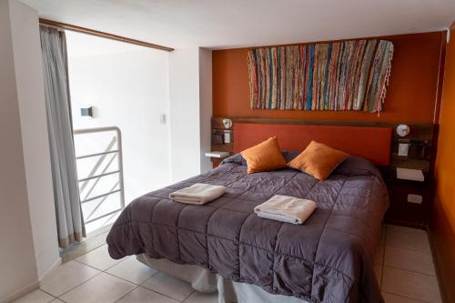 圣卡洛斯-德巴里洛切Belgrano Decks II的一间卧室配有一张带两个枕头的床