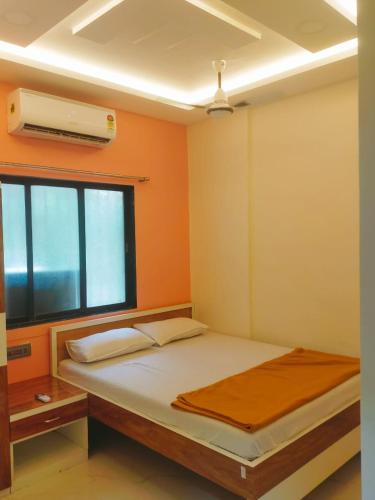 纳威孟买SAHIL STAY Inn的一间卧室设有一张床、一个窗口和风扇