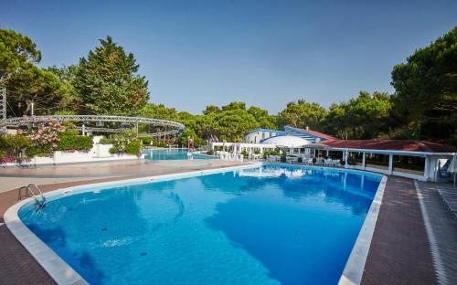 卡瓦利诺Dei Fiori Camping Village的一座大型蓝色游泳池,位于大楼旁边
