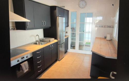 卡勒达德福斯特Villa Rochelle的厨房配有黑色橱柜和不锈钢冰箱