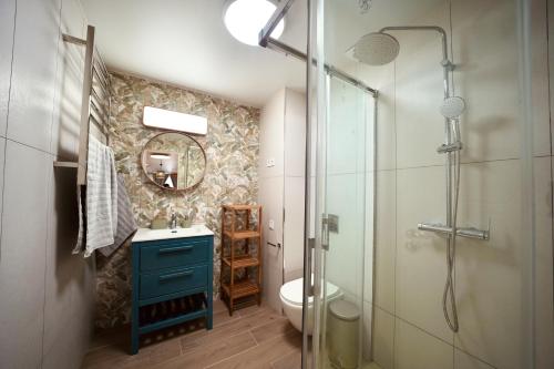 圣波拉Parsami Suites的浴室配有蓝色水槽和淋浴。