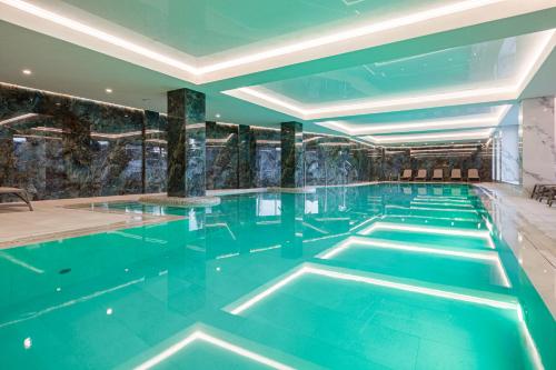布克维Tavel Hotel & SPA的大楼内的一个蓝色海水游泳池