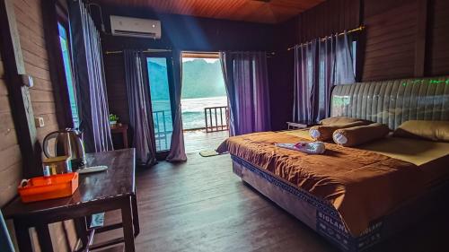 RabiaThe Jeti Mangrove - Ecolodge, Cottage, Restaurant & Kali Biru, Blue River的卧室配有床、桌子和窗户。