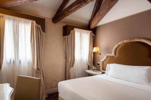 威尼斯Residenza Venezia | UNA Esperienze的酒店客房设有床和窗户。
