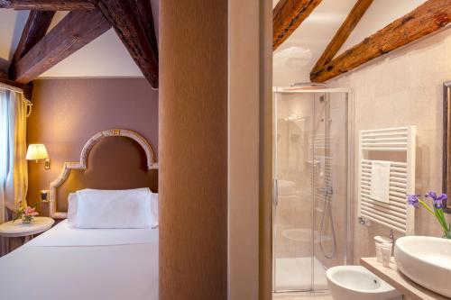 威尼斯Residenza Venezia | UNA Esperienze的一间卧室配有一张床、淋浴和盥洗盆