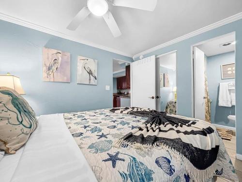 布雷登顿海滩Seaclusion Updated condo steps to beach & bay的一间卧室设有一张床和蓝色的墙壁