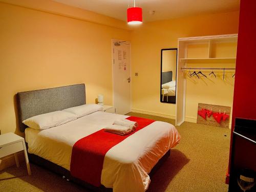 诺里奇Prince Apartment Inn的一间卧室配有一张床铺,床上铺有红色毯子