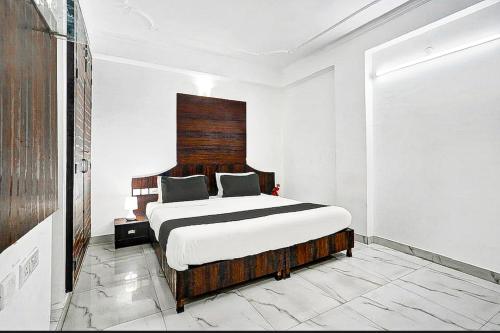 斋浦尔COLLECTION O HOTEL SKY INN的一间卧室配有一张大床和木制床头板