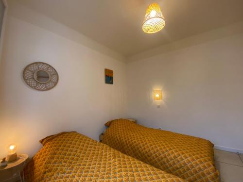 耶尔Rez de villa avec jardinet proche de la plage的一间卧室配有带2个枕头的床