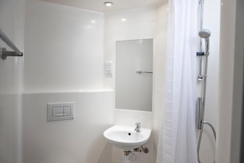 卢顿Wenlock Court的白色的浴室设有水槽和淋浴。