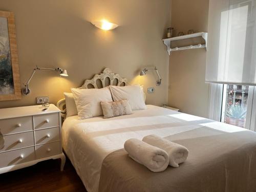 巴塞罗那佩蒂特罗瑟洛公寓的卧室配有白色的床和梳妆台。