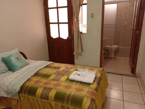 卡哈马卡Hostal Turismo Cruz de Piedra EIRL-Cajamarca的一间卧室配有一张床,浴室设有卫生间