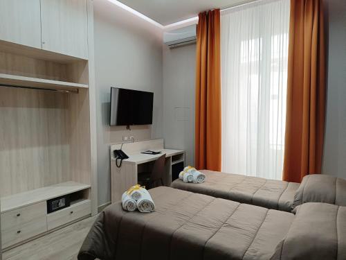那不勒斯斯可丽齐酒店的酒店客房设有两张床和电视。