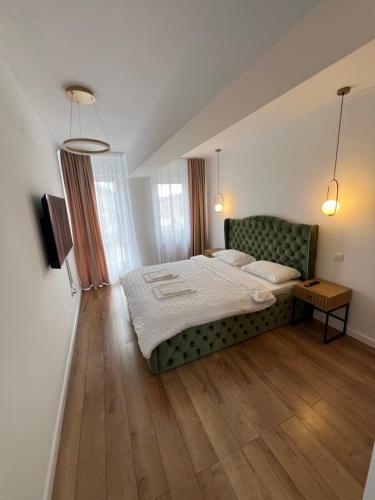 比斯特里察EightApartament的一间卧室配有一张床和一张绿色沙发