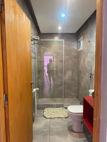 马拉圭Mi casa es tu casa!!的浴室设有卫生间和淋浴,浴室内有人淋浴。