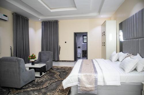 KarewaPula Pula Luxury Hotel and Suites的卧室配有一张白色大床和两把椅子