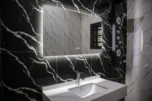 KarewaPula Pula Luxury Hotel and Suites的浴室设有白色水槽和镜子