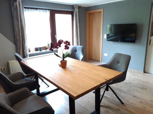 OsterbruchFewo Heimathafen的客厅配有一张木桌和椅子