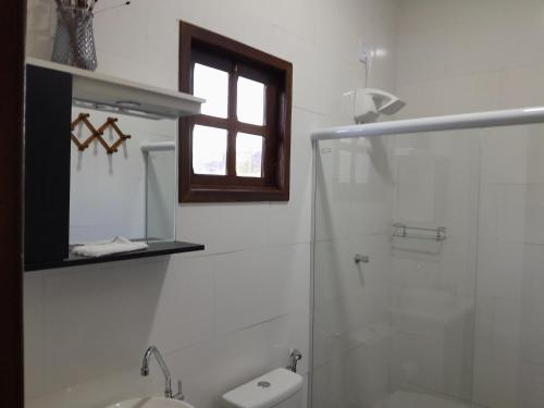 伊比科阿拉Pousada Campo Redondo的带淋浴和卫生间的浴室以及窗户。
