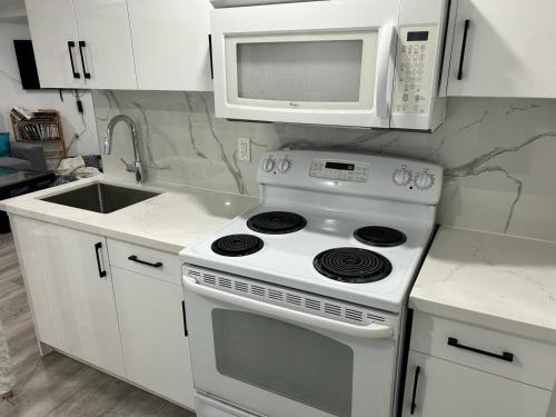 皮克灵Large Separate Entrance Basement Unit 2Beds 1Washroom Sleeps 4-6的白色的厨房配有炉灶和微波炉。