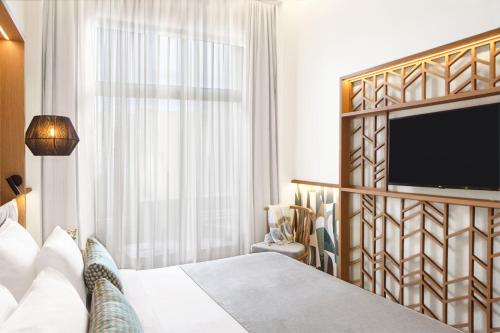阿基欧斯尼古拉斯Wyndham Grand Crete Mirabello Bay的配有一张床和一台平面电视的酒店客房