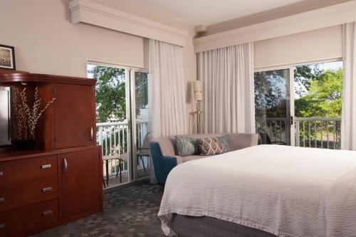 查尔斯顿查尔斯顿水岸万怡酒店的一间卧室配有一张床、一把椅子和窗户。