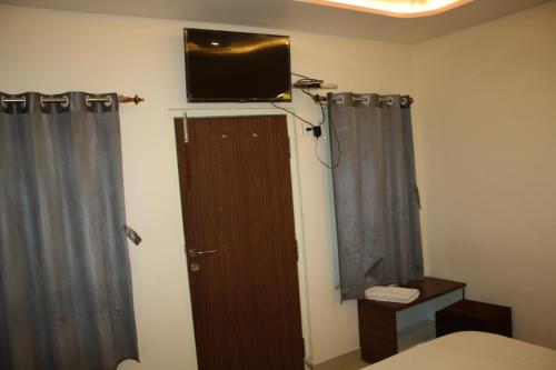 瓦拉纳西Raghunath Palace Home Stay的卧室设有墙上的电视和门