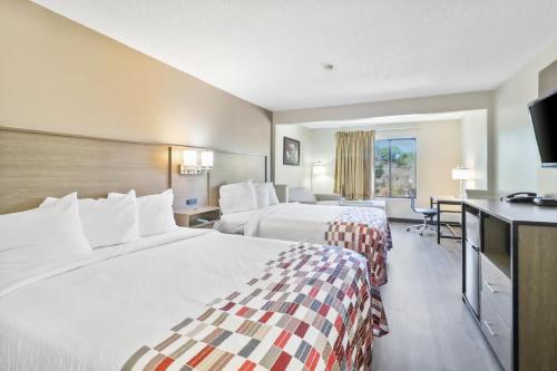 费耶特维尔Red Roof Inn & Suites Fayetteville-Fort Bragg的酒店客房设有两张床和一台平面电视。