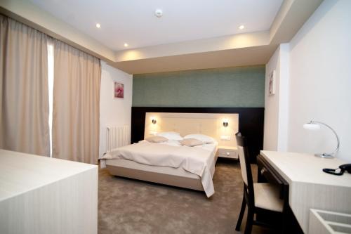 特尔戈维什泰Hotel Nova的一间卧室配有一张床、一张桌子和一张床