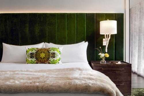 格林维尔Grand Bohemian Lodge Greenville, Autograph Collection的一间卧室配有一张大床和绿色床头板