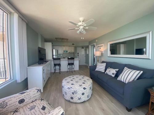 迈尔斯堡海滩Lover's Key Resort by Check-In Vacation Rentals的客厅配有蓝色的沙发和吊扇