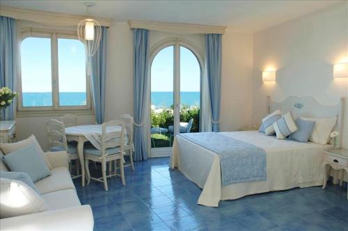瓦斯托拜亚戴菲斯度假酒店的卧室配有一张床和一张桌子及椅子