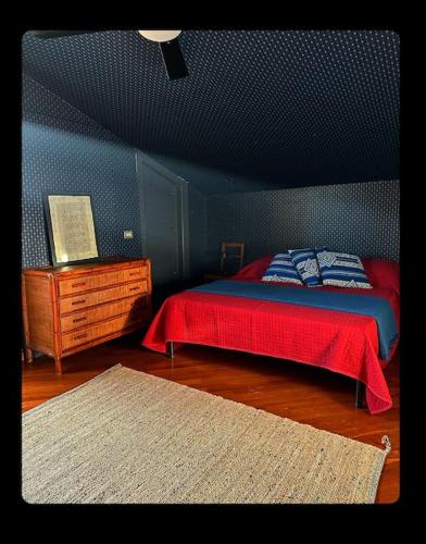 特尔尼Mansarda Centro storico Caprilla Guest Flat的一间卧室设有红色的床和蓝色的墙壁